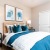 Model bedroom at our 55+ senior community in Palm Desert, featuring colorful bedding and carpeted flooring.